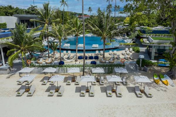 Luftaufnahme des Meliá Koh Samui Hotels mit Pool, Liegen und Sonnenschirmen am Strand