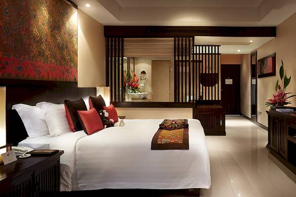 Hotelzimmer im Bo Phut Resort & Spa mit Bett, Fernseher und Dekor.