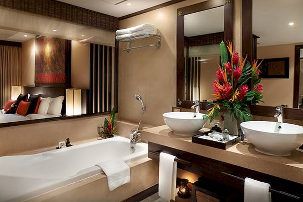 Bo Phut Resort & Spa Badezimmer mit Badewanne, zwei Waschbecken und Spiegeln.