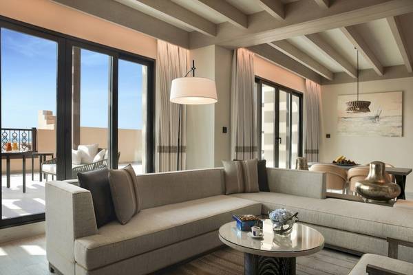 Modernes Wohnzimmer mit großem Sofa, Tisch, Lampen und Panoramafenstern im Saadiyat Rotana Resort & Villas.