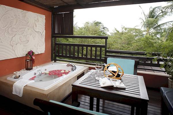 Balkon mit Jacuzzi im Bo Phut Resort & Spa, mit Blick auf Bäume und Pflanzen.