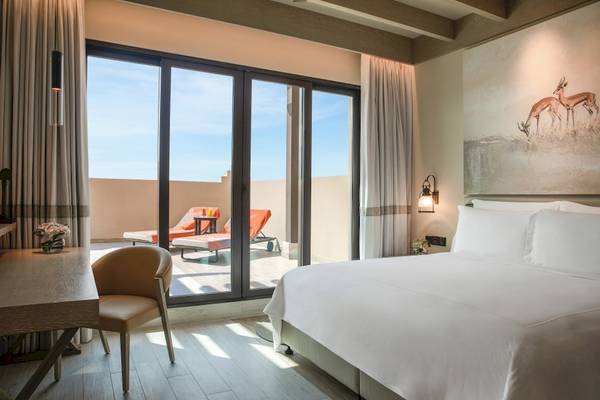 Schlafzimmer im Saadiyat Rotana Resort & Villas mit Blick auf einen Balkon.