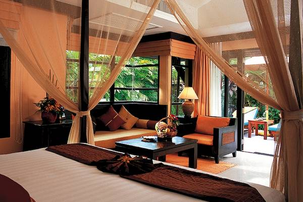 Schlafzimmer im Bo Phut Resort & Spa mit Himmelbett, Fenstern, Sesseln und Tisch