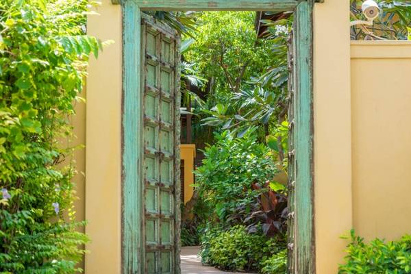 Offener grün gestrichener Türeingang zum Garten des Buri Rasa Village Samui