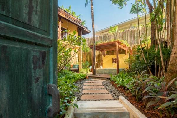 Gartenbereich des Buri Rasa Village Samui Hotels mit Gehweg und Pavillon