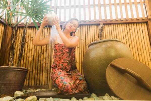 Frau im Buri Rasa Village Samui bei einem Brunnen