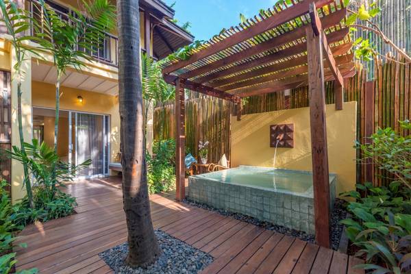 Außenbereich des Buri Rasa Village Samui Hotels mit Wasseranlage und Holzdeck.