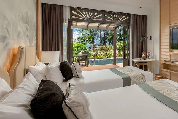 Doppelbettzimmer im Khao Lak Merlin Resort mit Blick auf den Swimmingpool und Außenbereich.