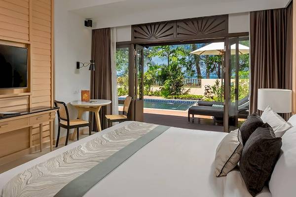 Hotelzimmer mit Poolblick im Khao Lak Merlin Resort, inklusive Fernseher, Tisch, Stühle und Pool.