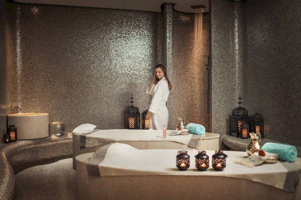Spa-Bereich im Saadiyat Rotana Resort & Villas mit einer Frau im weißen Bademantel.