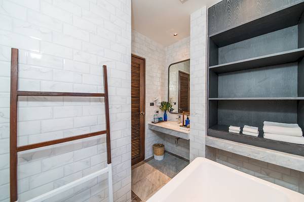 Badezimmer im Peace Resort mit Badewanne, Dusche, Toilettenpapierhalter und Regal mit Handtüchern.