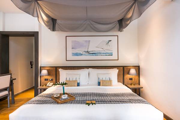 Ein geräumiges Schlafzimmer mit einem großen Bett, Dekorelementen und einer malerischen Wanddekoration.