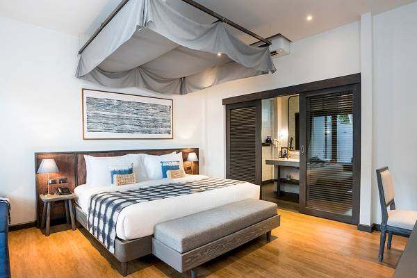 Schlafzimmer mit einem Bett, Nachttisch und Lampe, Peace Resort