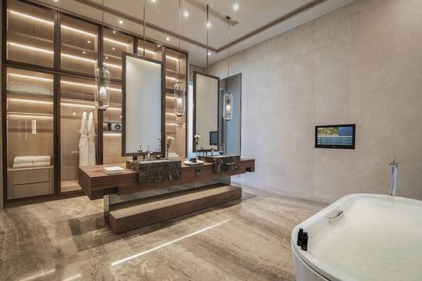 Ein Badezimmer im Saadiyat Rotana Resort & Villas mit einer Badewanne, zwei Waschbecken und einer Fernsehwand.