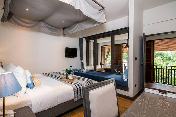 Schlafzimmer mit Bett, Balkon und Fernseher im Peace Resort