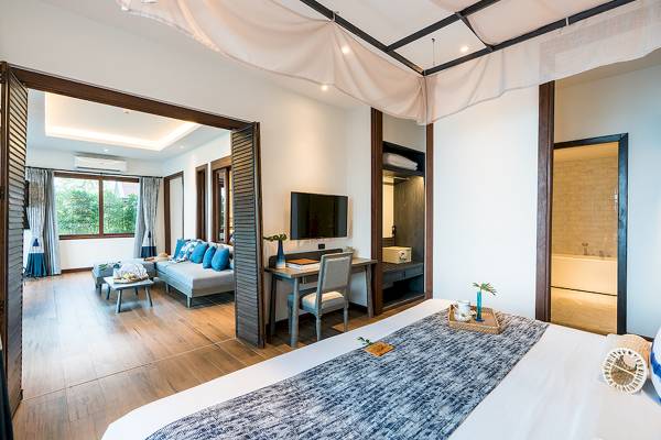 Innenansicht des Peace Resort Hotels mit Bett, Schreibtisch und Badewanne.