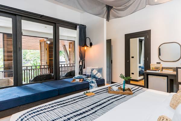 Schlafzimmer mit Balkon im Peace Resort mit zwei Betten, einer Lampe und einer Aussicht auf die Natur.