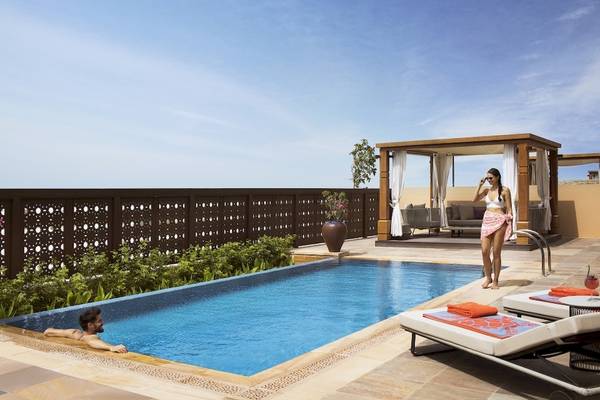 Ein Schwimmbad im Saadiyat Rotana Resort mit einer Frau am Poolrand und einem Mann im Pool.