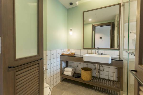 Badezimmer im Anana Ecological Resort Krabi mit Waschbecken, Spiegel und Toilette.
