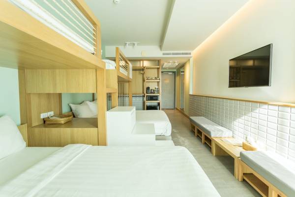 Innenansicht eines Zimmers im Anana Ecological Resort Krabi mit Etagenbetten, Fernseher und bequemen Sitzgelegenheiten.