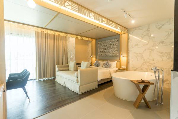 Schlafzimmer im Anana Ecological Resort Krabi mit Badewanne, Bett und Sitzecke.