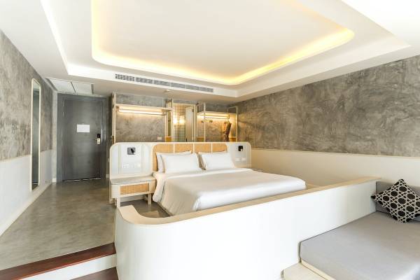 Innenansicht eines Zimmers im Anana Ecological Resort Krabi mit einem großen Bett, grauen Wänden und modernen Möbeln.