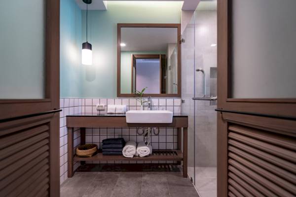 Badezimmer im Anana Ecological Resort Krabi mit weißem Waschbecken und grüner Pflanze.