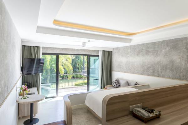 Innenansicht eines Hotelzimmers im Anana Ecological Resort Krabi mit Bett, Fernseher und Balkon