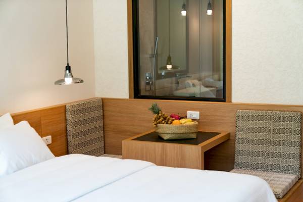 Ein Hotelzimmer des Anana Ecological Resort Krabi mit Bett, Obstkorb und Badezimmerspiegel.