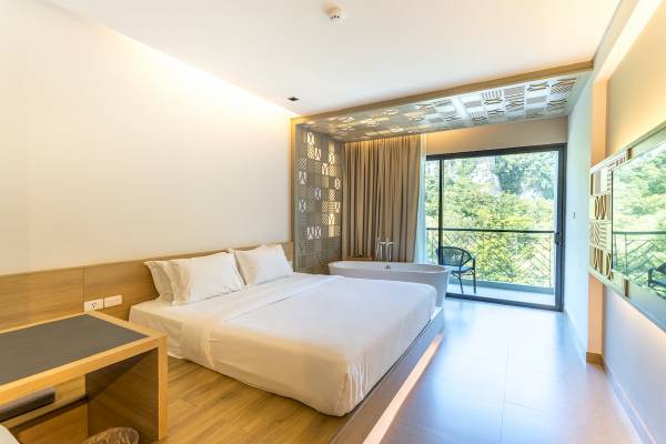 Hotelzimmer im Anana Ecological Resort Krabi mit Bett, Badewanne und Balkon.