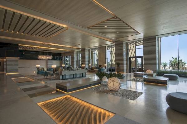 Lobby des Saadiyat Rotana Resort & Villas mit modernen Möbeln und großen Fenstern.