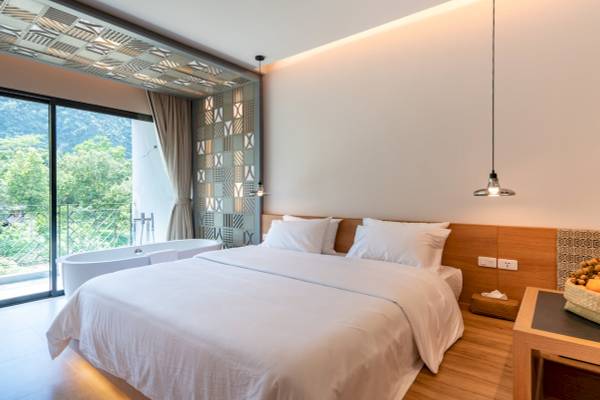 Schlafzimmer im Anana Ecological Resort Krabi mit Bett und Badewanne.