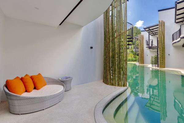 Pool-Loungebereich im Anana Ecological Resort Krabi mit weißen Wänden und Bambuswänden.