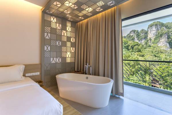 Innenansicht eines Zimmers im Anana Ecological Resort Krabi mit Badewanne und Ausblick auf einen Berg.