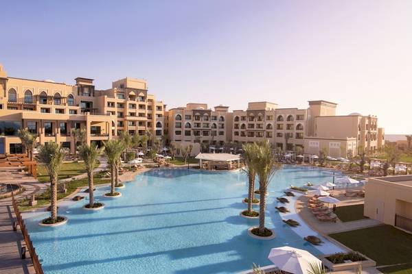 Außenbereich des Saadiyat Rotana Resort & Villas mit großem Swimmingpool und Lounge-Bereichen.