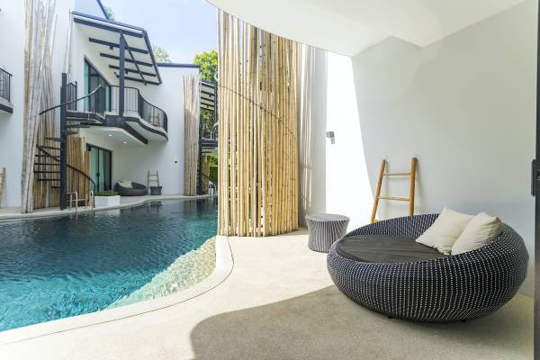 Außenbereich des Anana Ecological Resort Krabi mit Pool, Loungemöbeln und Bambuswänden.