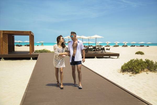 Paar am Strand des Saadiyat Rotana Resorts & Villas