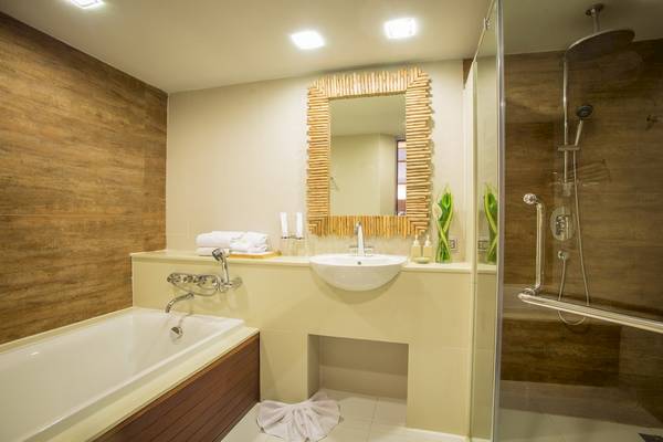Badezimmer im Tup Kaek Sunset Beach Resort mit Badewanne, Waschbecken und Dusche.