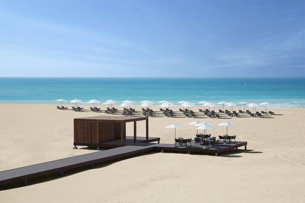 Strand des Saadiyat Rotana Resort & Villas mit Sonnenliegen und Sonnenschirmen