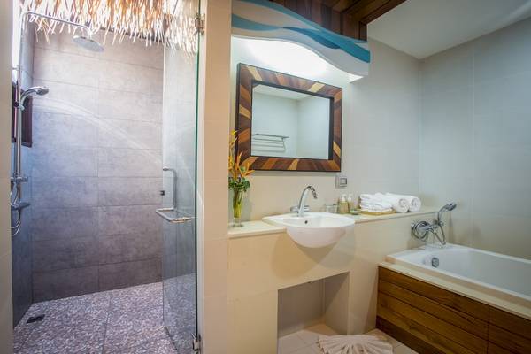 Badezimmer im Tup Kaek Sunset Beach Resort mit Dusche, Waschbecken und Badewanne.