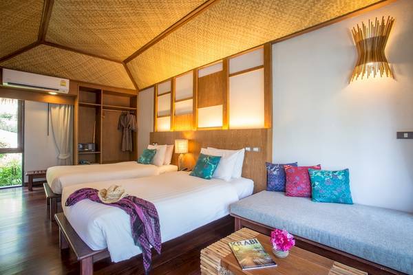 Hotelzimmer im Tup Kaek Sunset Beach Resort mit zwei Betten, Decken und Kissen.
