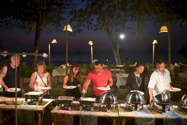 Mehrere Personen bei einem Buffet im Freien beim Tup Kaek Sunset Beach Resort bei Nacht.