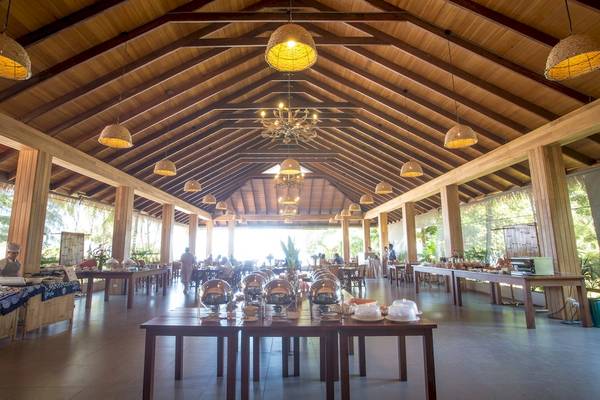 Innenansicht des Restaurants im Tup Kaek Sunset Beach Resort mit Holzmöbeln und dekorativen Lampen.