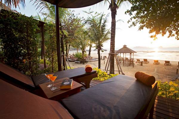 Loungebereich des Tup Kaek Sunset Beach Resorts mit Blick auf den Strand und das Meer bei Sonnenuntergang.