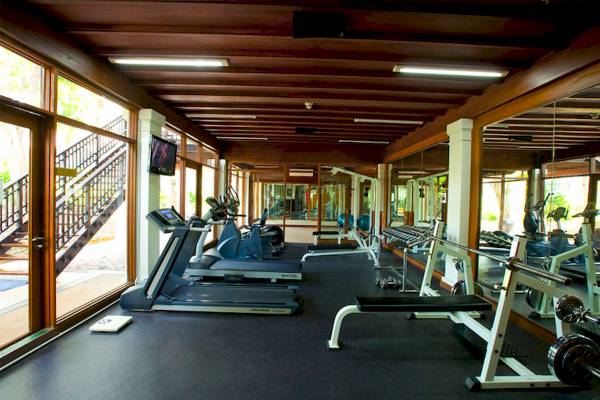 Fitnesscenter im Aonang Villa Resort mit Laufbändern, Hanteln und Spiegeln.