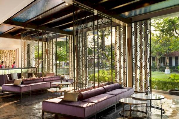 Empfangshalle des Aonang Villa Resorts mit violetten Sofas und modernen Metallschirmen.
