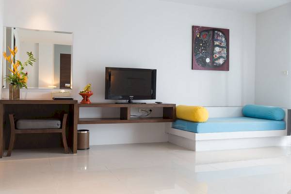 Friedens Lagune Resort & Spa Hotelzimmer mit Fernseher, Schreibtisch und Couch.