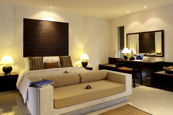 Schlafzimmer im Peace Laguna Resort & Spa mit einem großen Bett, Sofa-Bett, Nachttischen und Schreibtisch.