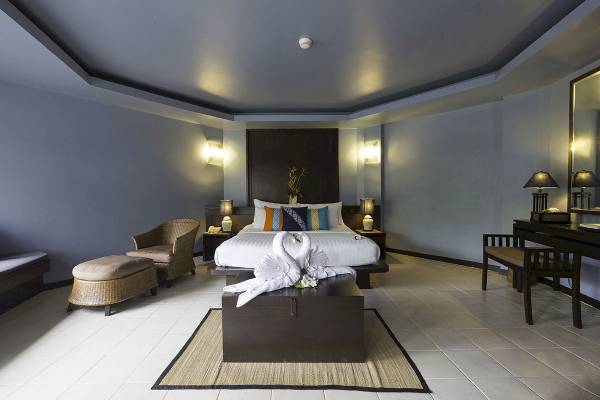 Ein modernes Schlafzimmer mit einem großen Bett, zwei weißen Schwanen und einem Nachttisch auf beiden Seiten.