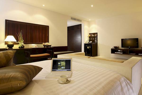 Hotelzimmer im Peace Laguna Resort & Spa mit Laptop auf Bett und Fernseher an der Wand